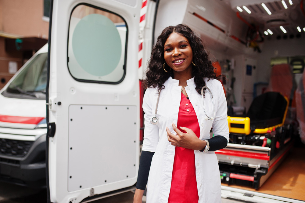 EMS worker stands at the back door of an ambulance