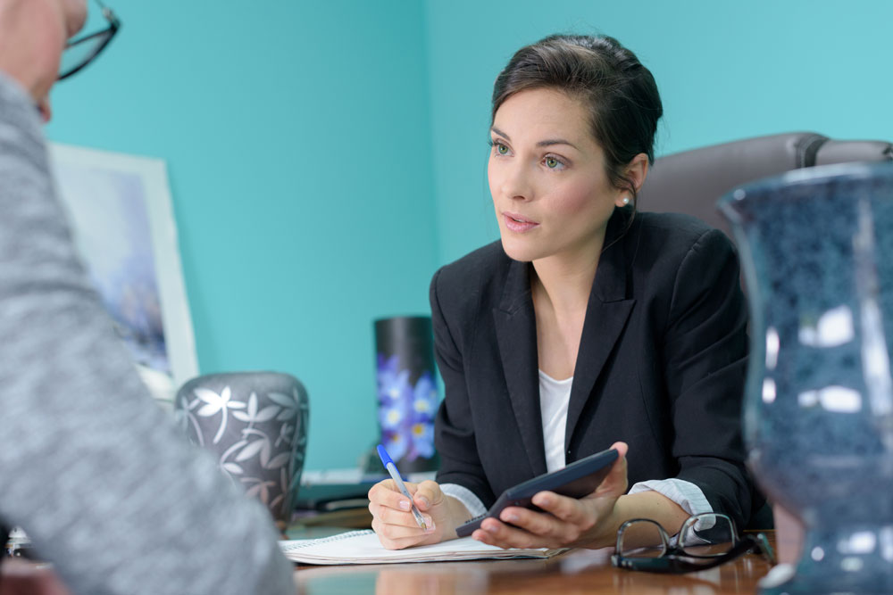 Funeral director sitting at desk taking notes