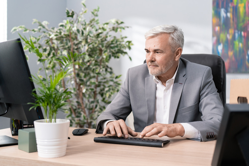 Funeral director types notes at his desk