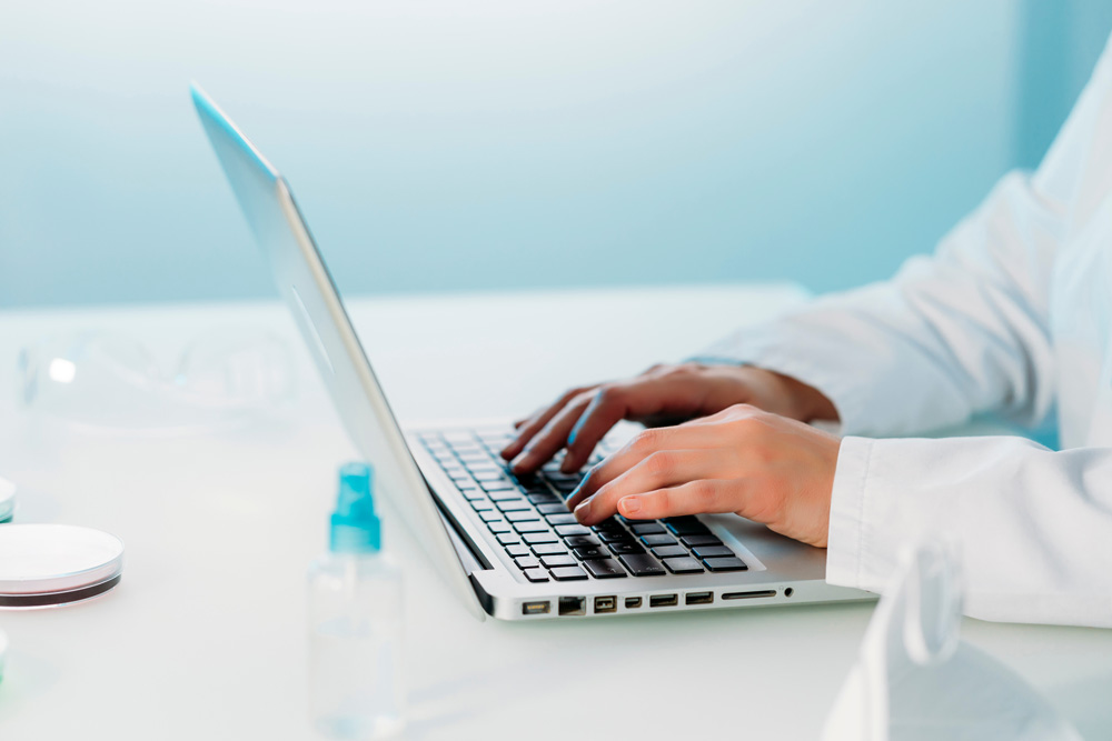 Medical examiner taking notes on laptop