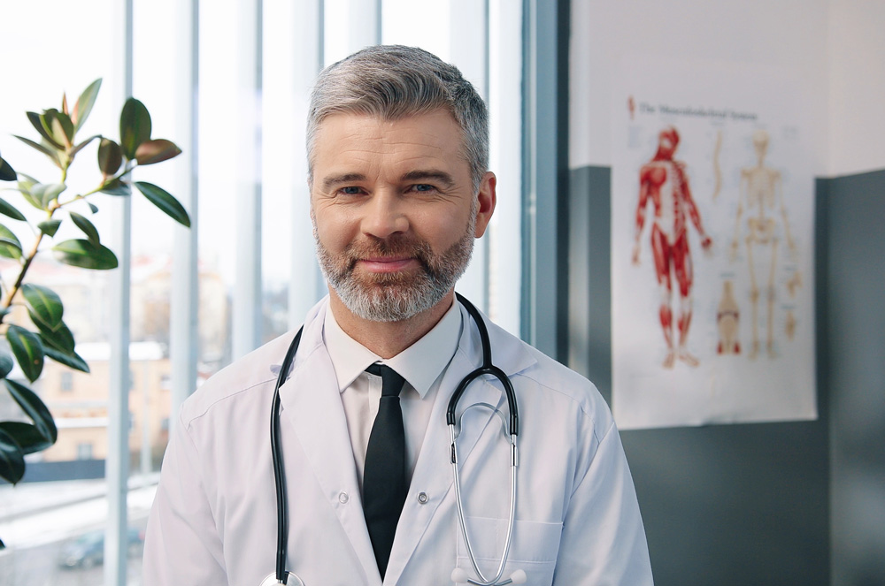 Medical examiner in office next to diagram of the human body