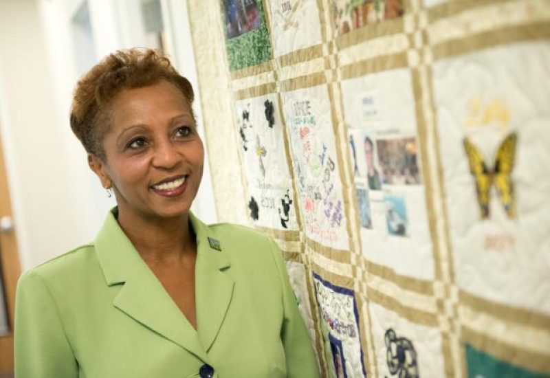 Woman looks at yellow donor quilt